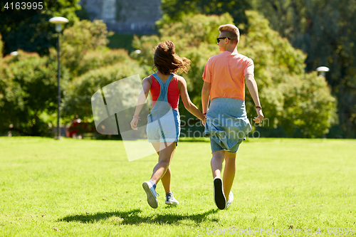 Image of happy teenage couple walking at summer park