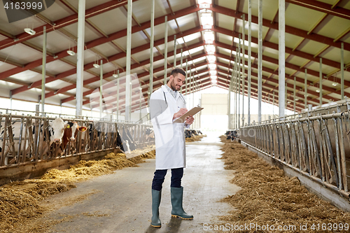 Image of veterinarian with cows in cowshed on dairy farm