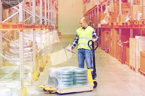 Image of man with loader and clipboard at warehouse