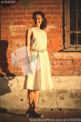 Image of woman standing near ancient brick wall