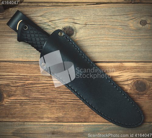 Image of steel hunting knife in leather sheath