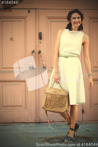 Image of smiling beautiful woman in white dress