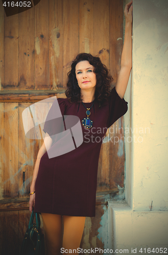 Image of beautiful woman in a fashionable burgundy dress