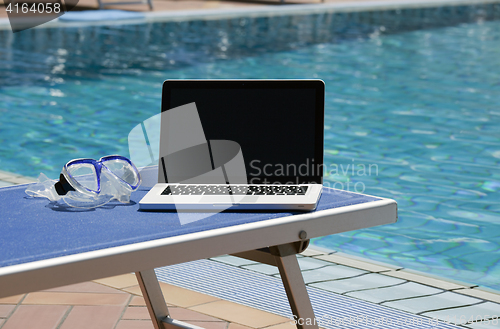 Image of Laptop computer near swimming pool 