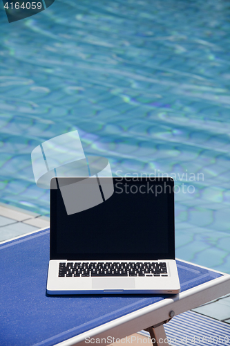 Image of Laptop computer near swimming pool 