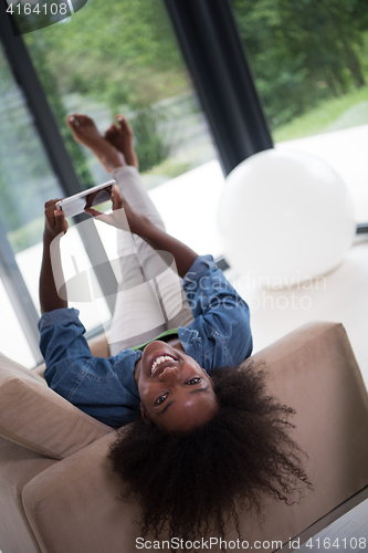 Image of african american woman at home with digital tablet