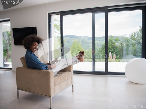 Image of african american woman at home with digital tablet