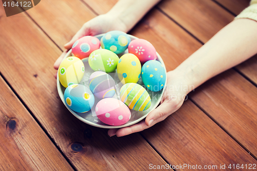 Image of close up of woman hands with colored easter eggs