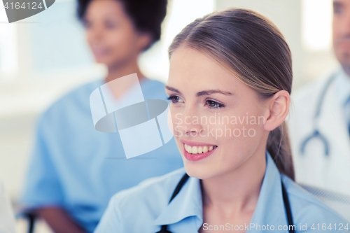 Image of happy doctor over group of medics at hospital