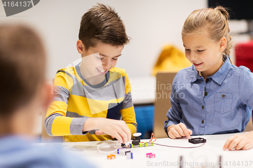 Image of happy children building robots at robotics school