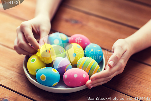 Image of close up of woman hands with colored easter eggs