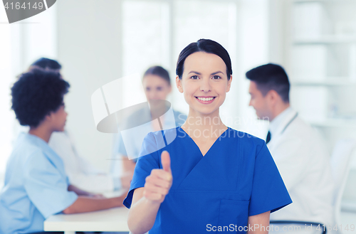 Image of happy doctor over group of medics at hospital