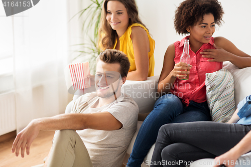 Image of friends with beer talking and watching tv at home