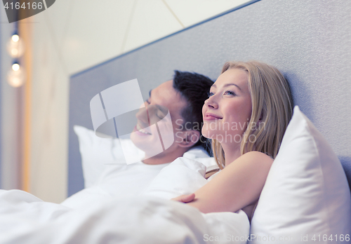 Image of happy couple dreaming in bed