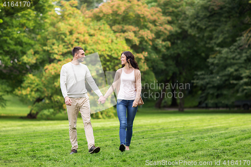 Image of happy couple walking in summer park