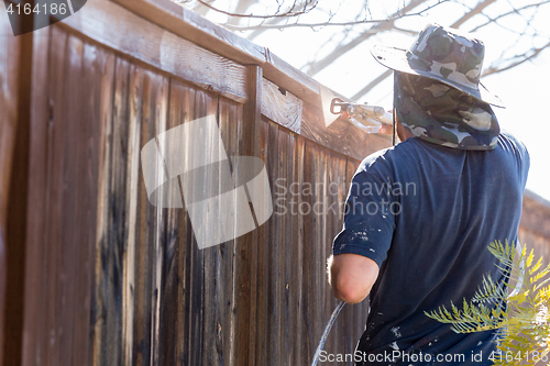 Image of Professional Painter Spraying Yard Fence with Stain