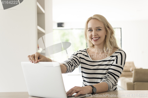 Image of Young woman with laptop at home