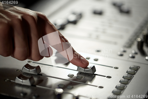 Image of hand with mixing console in music recording studio