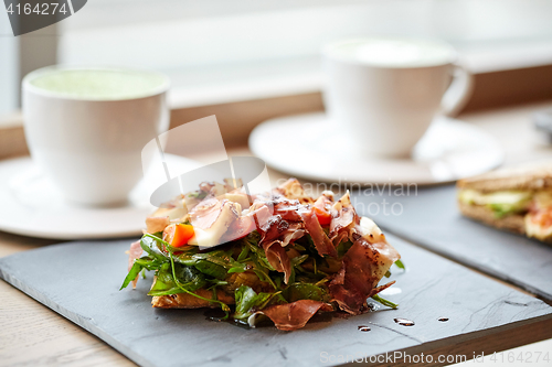 Image of prosciutto ham salad on stone plate at restaurant