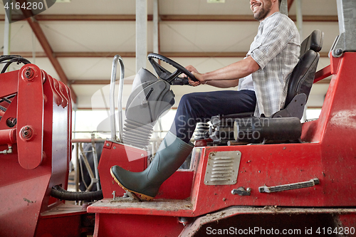 Image of man or farmer driving tractor at farm