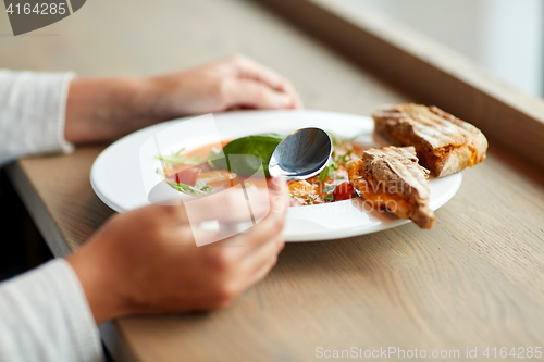 Image of woman eating gazpacho soup at restaurant