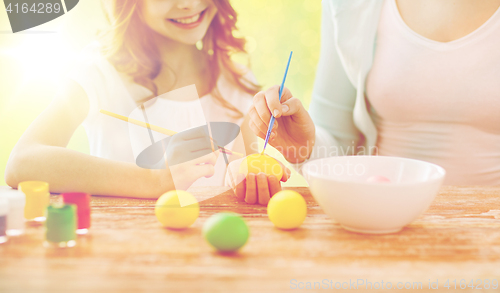 Image of close up of family coloring easter eggs