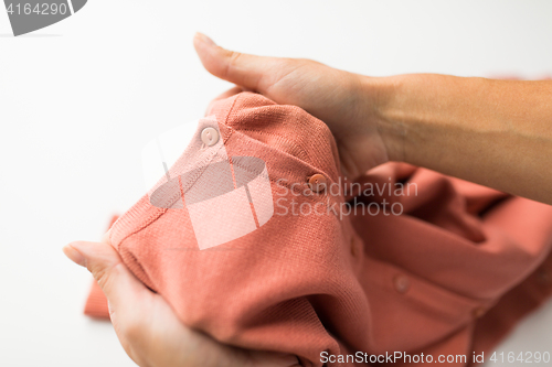 Image of close up of hands with clothing item or cardigan