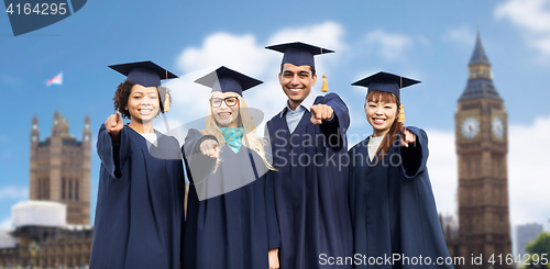 Image of happy students or bachelors pointing finger at you