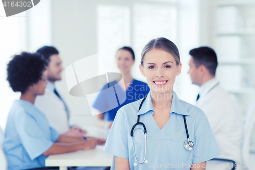 Image of happy doctor over group of medics at hospital