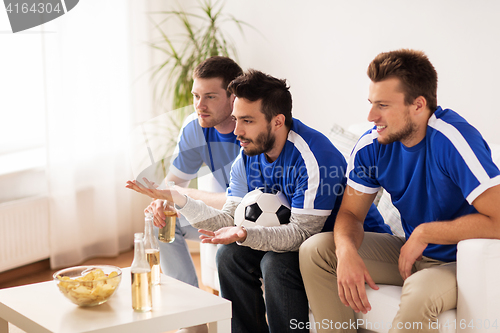 Image of friends or football fans watching soccer at home