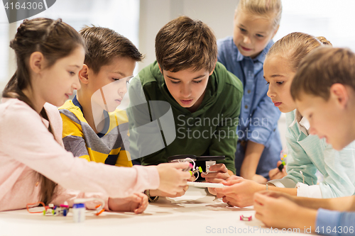 Image of happy children building robots at robotics school