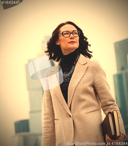 Image of Smiling dark-haired businesswoman in a bright coat