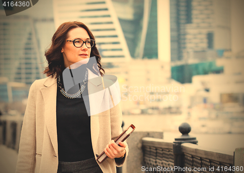 Image of portrait of a beautiful middle-aged woman with books in hand