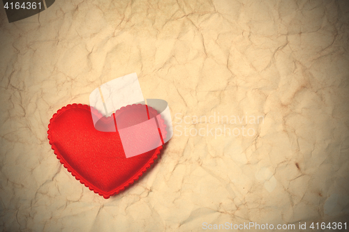 Image of old wrinkled paper background and red hear