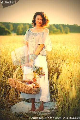 Image of Beautiful middle-aged woman standing in a wheat field