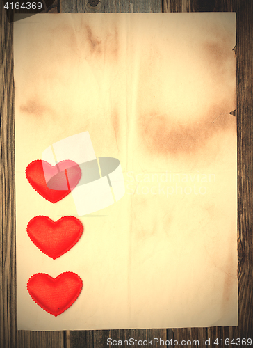 Image of blank old paper with three red hearts