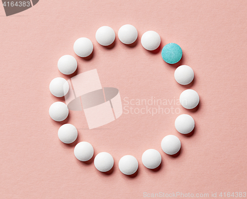 Image of white pills on pink background