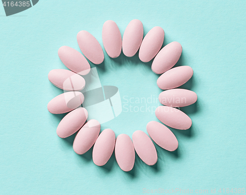 Image of pink pills on blue background