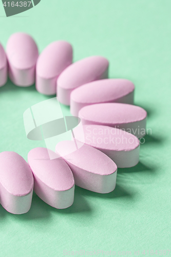 Image of pink pills on green background