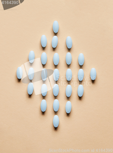 Image of blue pills on beige background