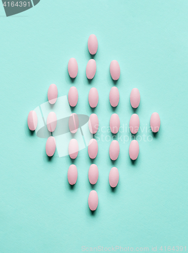 Image of pink pills on blue background