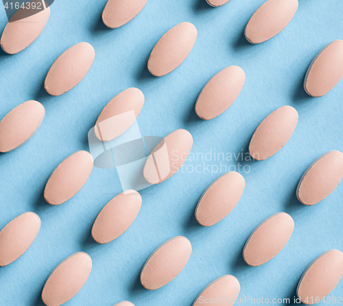 Image of pink pills on blue background