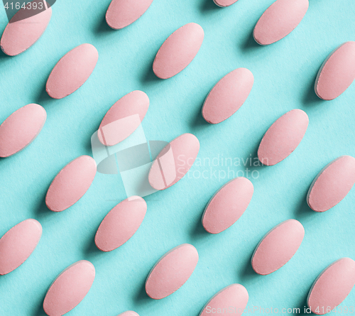 Image of pink pills on blue background