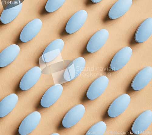 Image of blue pills on beige background