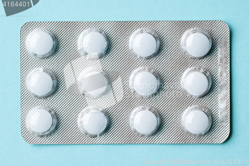 Image of white pills on blue background