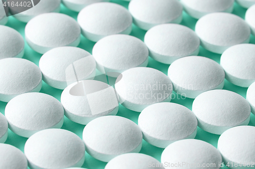 Image of white pills on blue background