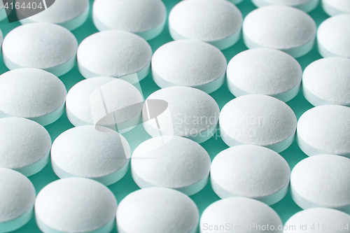 Image of white pills on blue background