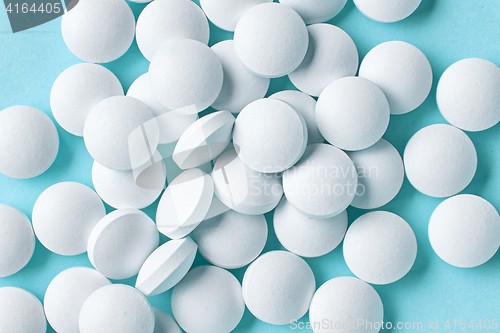 Image of white pills on blue background