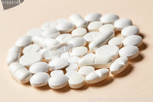 Image of white pills on beige background