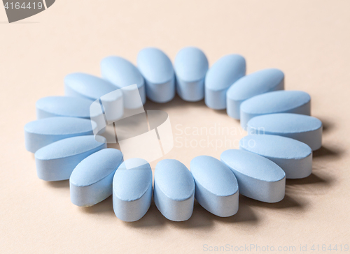 Image of blue pills on beige background